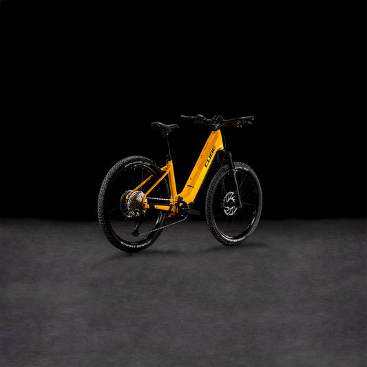 Vor einem dunklen, nahtlosen Hintergrund ist ein Cube Reaction Hybrid SLX 800 spectraorange´n´violet Easy Entry 2025 E-Bike von CUBE mit robusten Reifen und stabilem Rahmen abgebildet.