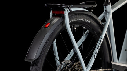 Nahaufnahme des Hinterrads und des Schutzblechs des CUBE Kathmandu Hybrid EX 800 haze´n´black 2025 mit Magura MT C ABS-Scheibenbremsen, Gepäckträger, Schwalbe-Reifen, Gangschaltung und Reflektor vor schwarzem Hintergrund.