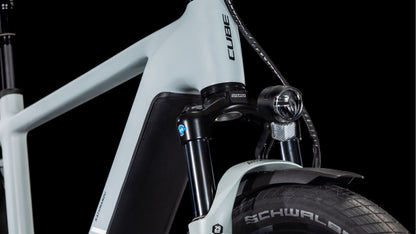 Nahaufnahme des Vorderrahmens, der Gabel, der Federung, des Schwalbe-Reifens, des Bosch CX-Motors und des Scheinwerfers des CUBE Kathmandu Hybrid EX 800 haze´n´black 2025. Markendetails und elegante Designelemente heben sich vom schwarzen Hintergrund ab.