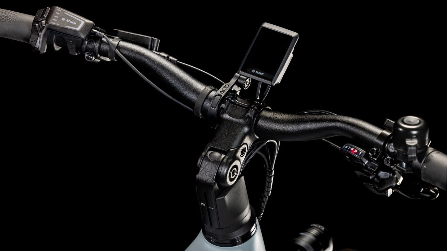 Nahaufnahme des CUBE Kathmandu Hybrid EX 800 haze´n´black Trapeze 2025-Lenkers mit Bosch-Display, Magura MT C ABS-Bedienelementen (links) und Gangschaltung (rechts) vor schwarzem Hintergrund.