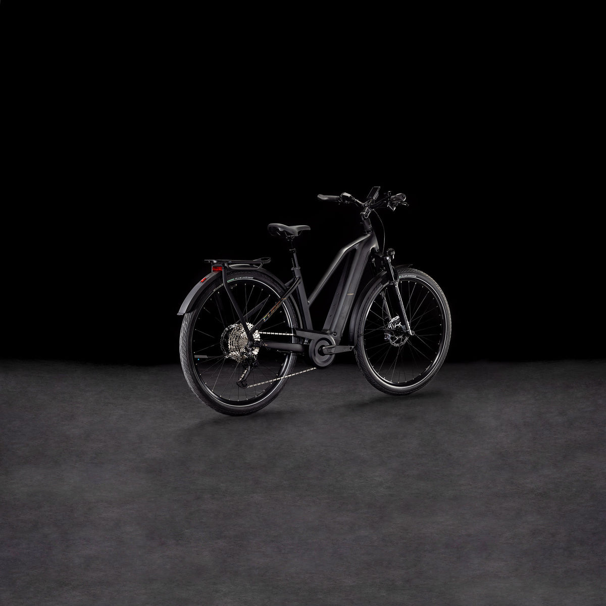 Das CUBE Kathmandu Hybrid EXC 800 black'n'prism Trapeze 2025 Elektrofahrrad ist auf einer dunklen Fläche mit schwarzem Hintergrund ausgestellt, von hinten gesehen.