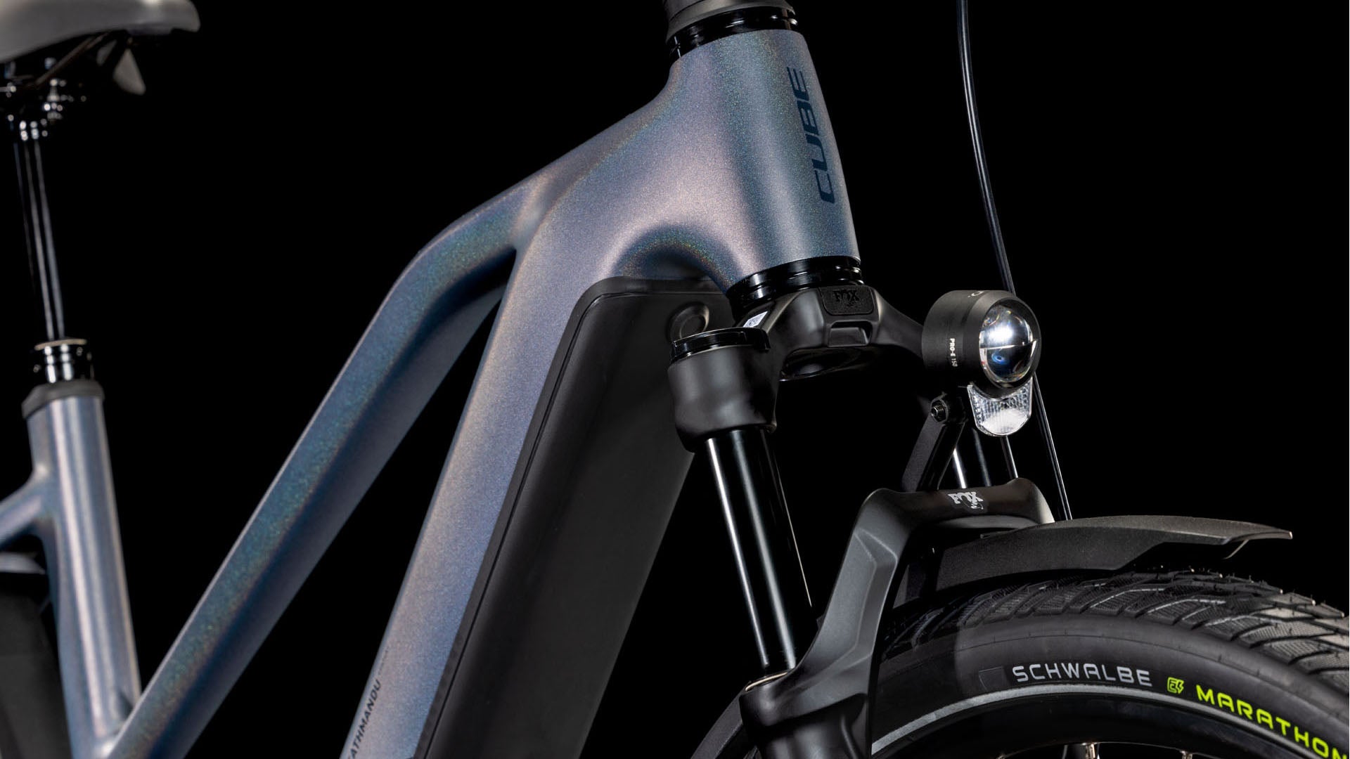 Nahaufnahme des Vorderrahmens und der Federgabel des CUBE Kathmandu Hybrid Comfort SLX 800 nightsky´n´ink Trapeze 2025 mit Schwalbe Marathon-Reifen, Bosch CX-Motor und elegantem Branding vor schwarzem Hintergrund.