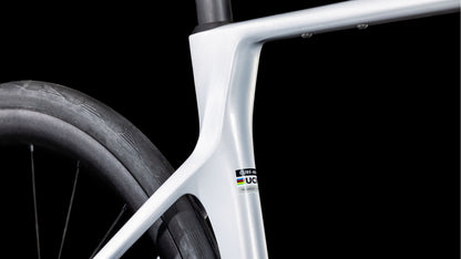 Nahaufnahme des eleganten CUBE Agree C:62 ONE foggrey'n'grey 2025 Rahmens in Silber, der das Sitzrohr, das Oberrohr und das Hinterrad hervorhebt. Der UCI-zertifizierte Rahmen ist mit Shimano 105 Di2-Komponenten ausgestattet, die vor einem schwarzen Hintergrund stehen.
