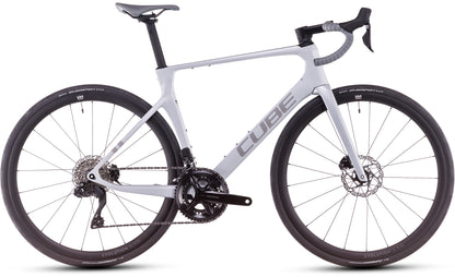 Das Cube Agree C:62 ONE foggrey'n'grey 2025 von CUBE zeigt sich im Profil mit weißem Rahmen, schwarzem Lenker, zwei großen schwarzen Laufrädern, Scheibenbremsen, Shimano 105 Di2 und Dropbars. Das CUBE-Logo ist auf dem Rahmen sichtbar.
