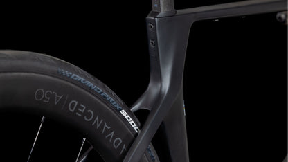 Nahaufnahme des Cube Agree C:62 Pro blackline 2025 von CUBE, die den mattschwarzen Carbonrahmen und das Hinterrad mit dem Schriftzug ADVANCED 4.50" auf dem Reifen hervorhebt - ein aerodynamisches Design, das sich ideal für Straßenrennen eignet, vor schwarzem Hintergrund.