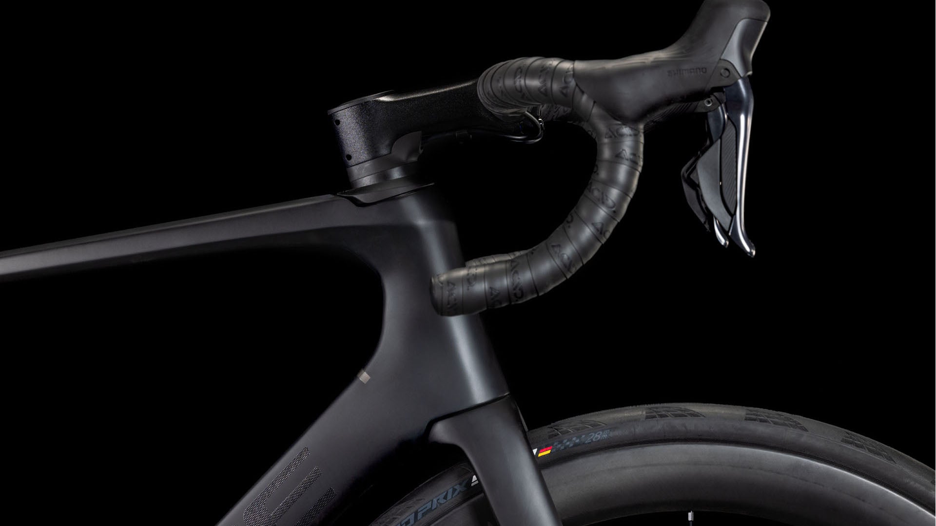 Nahaufnahme des vorderen Teils des CUBE Agree C:62 Pro blackline 2025 mit Lenker, Bremshebel, Vorderrad und einem Teil des C:62 Carbon-Rahmens vor einem schwarzen Hintergrund.