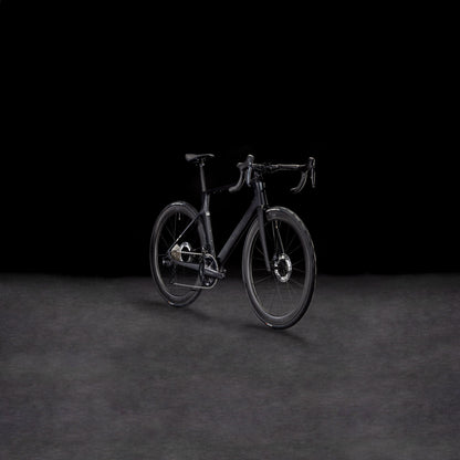 Das CUBE Agree C:62 Pro blackline 2025 mit C:62 Carbon-Rahmen, Drop-Lenker und Scheibenbremsen wird auf einer dunklen, strukturierten Oberfläche vor einem soliden schwarzen Hintergrund dargestellt.