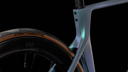 Nahaufnahme des Hinterrads und des Rahmens eines CUBE Agree C:62 Pro polarlight'n'aquagreen 2025 mit einem Continental-Reifen mit Gummikante und Metallic-Farbverlauf, hervorgehoben vor einem schwarzen Hintergrund.