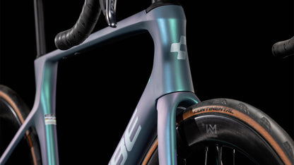 Nahaufnahme des CUBE Agree C:62 Pro polarlight'n'aquagreen 2025, die den schillernden Rahmen, die Gabel, den Lenker, den Continental-Reifen, das Cube-Logo auf dem Steuerrohr und die Shimano Ultegra Di2-Komponenten vor einem schwarzen Hintergrund hervorhebt.
