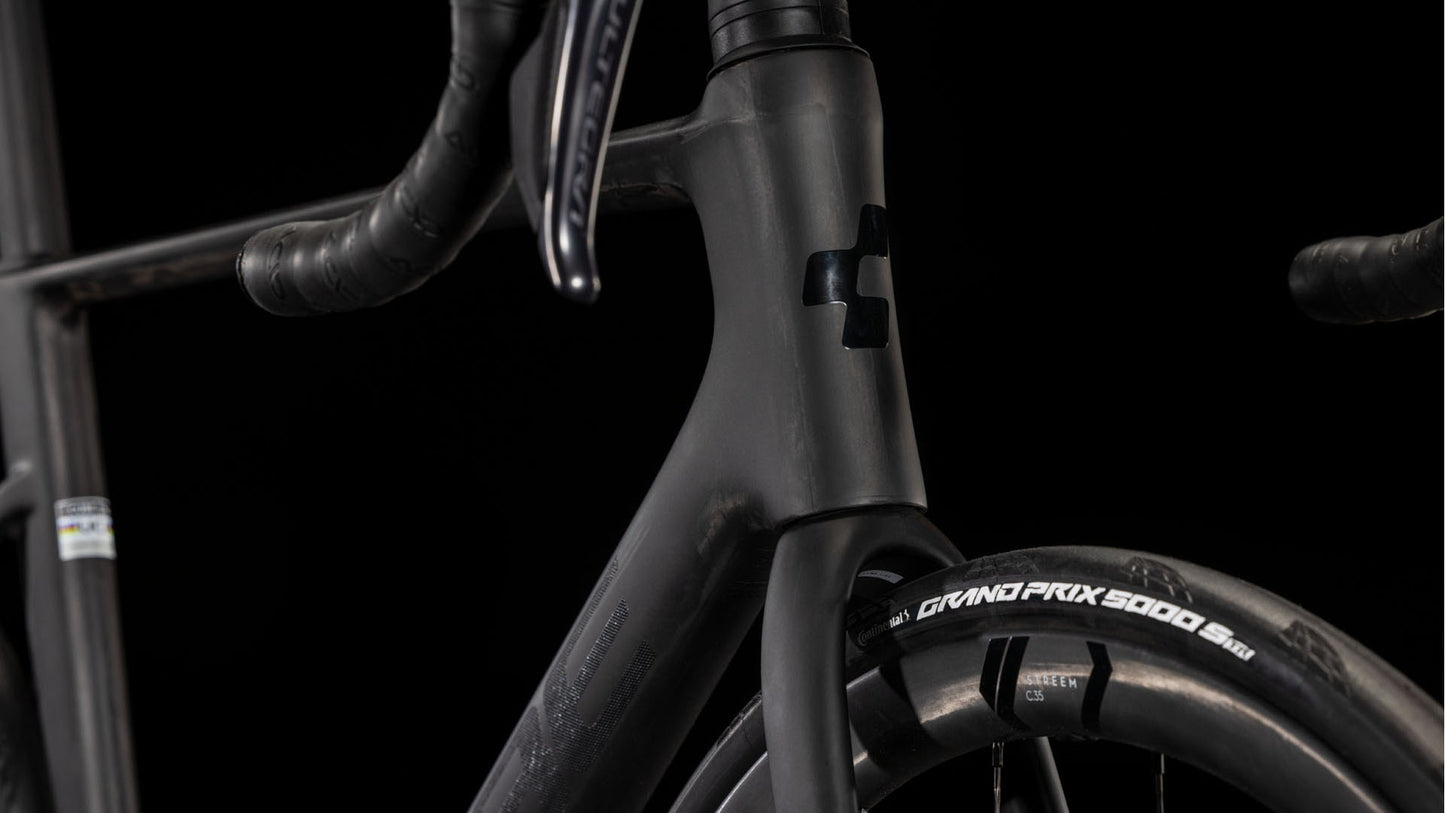 Nahaufnahme des CUBE Litening AIR C:68X Race blackline 2025 Rennrads mit Carbonrahmen, tiefem Lenker, CUBE-Logo am Steuerrohr, Shimano Ultegra Di2 Gruppe und Continental Grand Prix 5000 Reifen vor schwarzem Hintergrund.