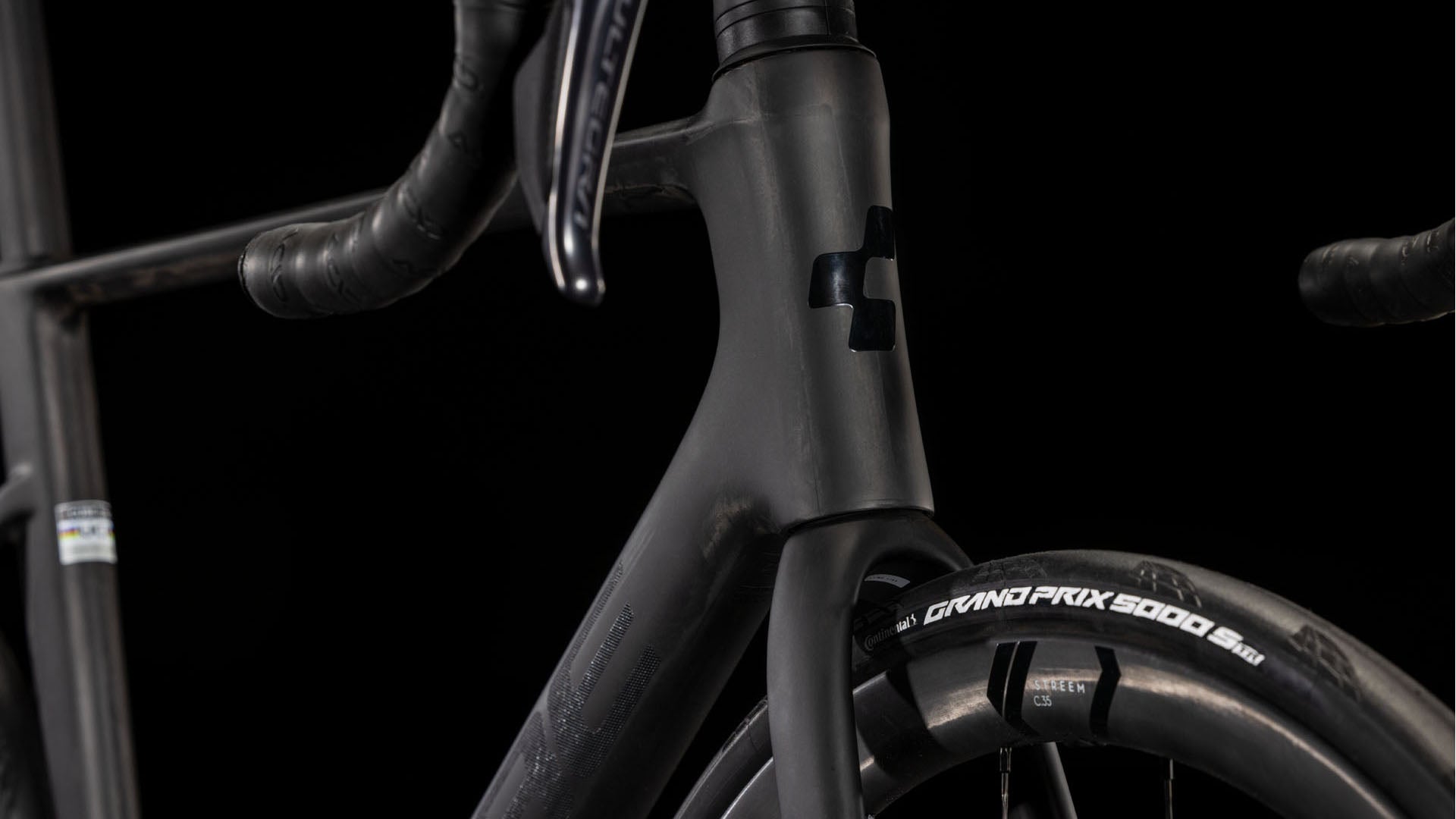 Nahaufnahme des CUBE Litening AIR C:68X Race blackline 2025 Rennrads mit Carbonrahmen, tiefem Lenker, CUBE-Logo am Steuerrohr, Shimano Ultegra Di2 Gruppe und Continental Grand Prix 5000 Reifen vor schwarzem Hintergrund.