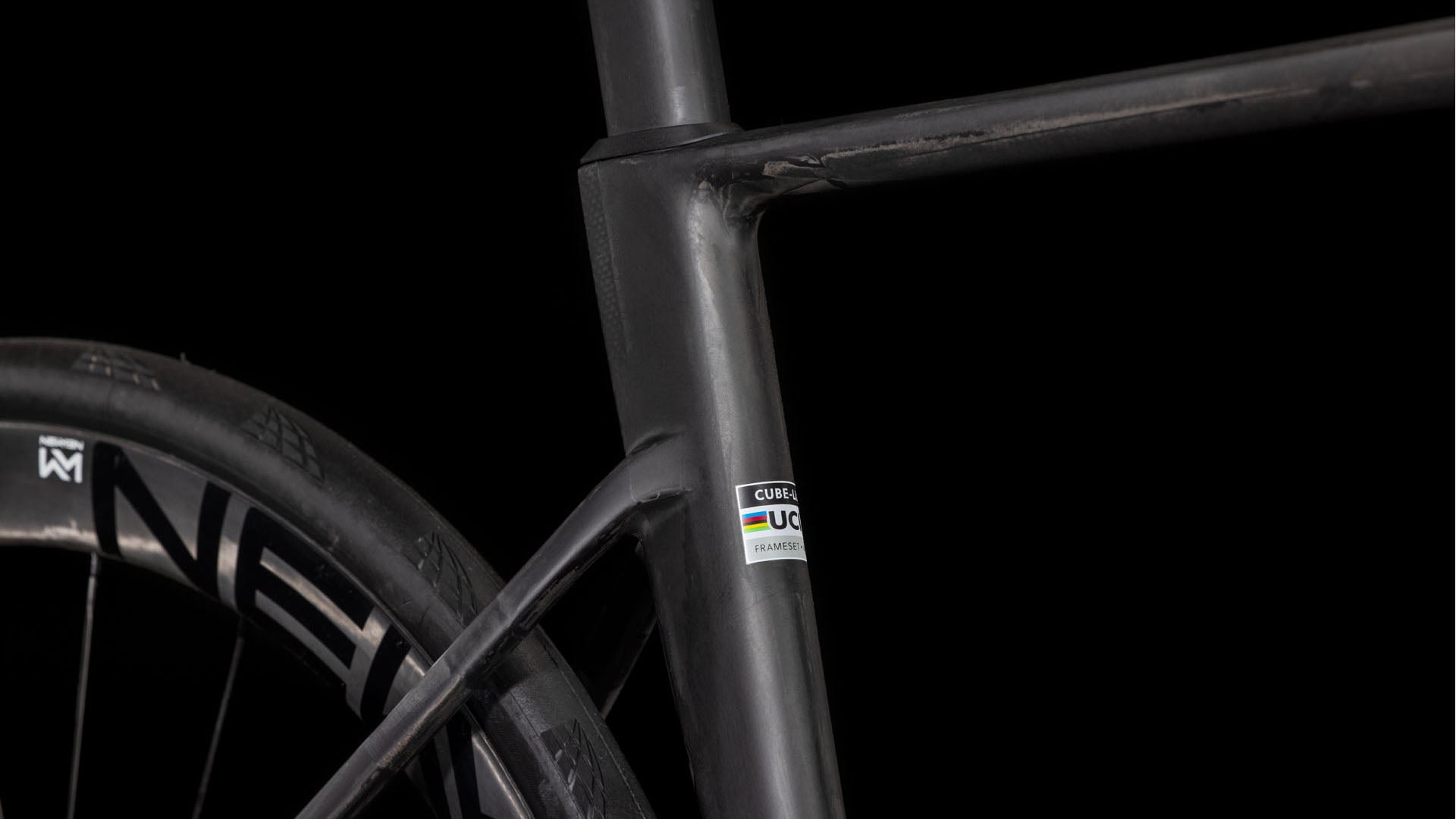 Die Nahaufnahme des mattschwarzen Carbonrahmens des CUBE Litening AIR C:68X Race blackline 2025 hebt das Sitzrohr, die Sitzstrebe, das Hinterrad und den UCI-Aufkleber hervor. Shimano Ultegra Di2-Teile betonen den schlanken Look vor schwarzem Hintergrund.