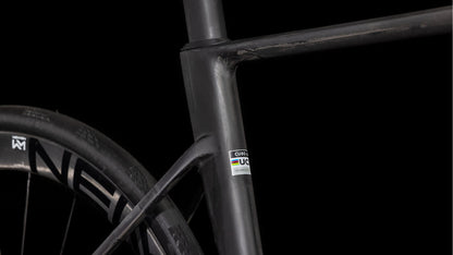 Die Nahaufnahme des mattschwarzen Carbonrahmens des CUBE Litening AIR C:68X Race blackline 2025 hebt das Sitzrohr, die Sitzstrebe, das Hinterrad und den UCI-Aufkleber hervor. Shimano Ultegra Di2-Teile betonen den schlanken Look vor schwarzem Hintergrund.