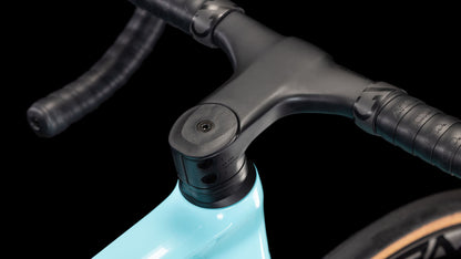 Nahaufnahme des CUBE Cube Litening AIR C:68X Race dazzle'n'black 2025 Lenker, Vorbau und Steuersatz in mattem Schwarz auf einem hellblauen Carbonrahmen mit Shimano Ultegra Di2, ein Teil des Vorderrads vor schwarzem Hintergrund.