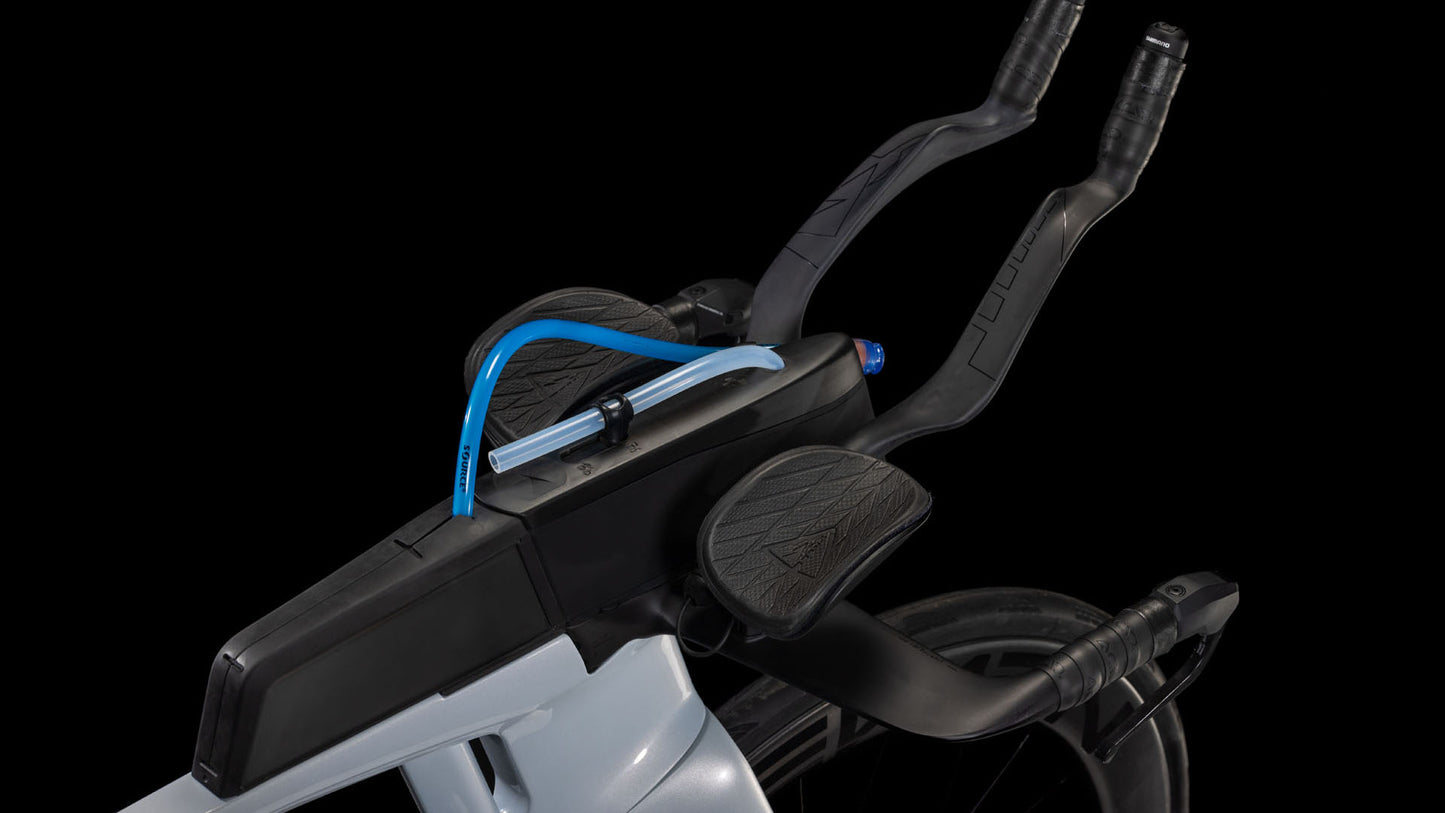 Nahaufnahme des CUBE Aerium C:68X Race foggrey'n'white 2026 Aero-Carbonlenkers mit Armlehnen und integriertem blauen Trinkhalm, der das schlanke, aerodynamische Design des Triathlonrads vor einem schwarzen Hintergrund zeigt.