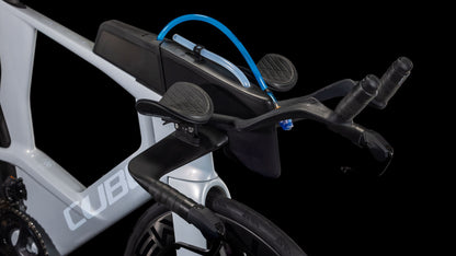 Nahaufnahme des Cube Aerium C:68X Race foggrey'n'white 2026 Triathlonrads von CUBE. Zu sehen sind ein Trinksystem, ein Aero-Lenker mit Armlehnen, Shimano Ultegra Di2 und das CUBE-Branding auf dem Rahmen vor einem schwarzen Hintergrund.