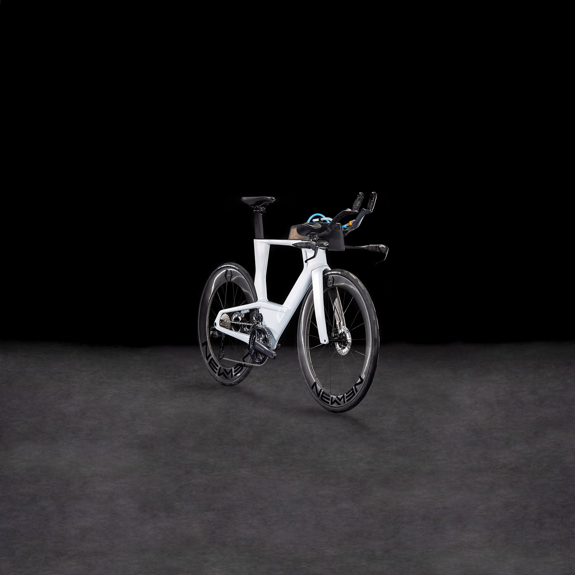 Das CUBE Aerium C:68X Race foggrey'n'white 2026 Carbon-Triathlonrad wird mit Tiefbett-Laufrädern, Shimano Ultegra Di2 und Aero-Lenker vor einem dunklen, nahtlosen Hintergrund gezeigt.