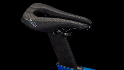 Nahaufnahme eines Selle Italia Watt-Sattels auf einem Cube Aerium C:68X SLT nebula'n'white 2026 Rennrad von CUBE. Der schwarze Sattel mit weißem Branding und zentraler Aussparung ist auf der Carbon-Sattelstütze montiert und steht vor einem schwarzen Hintergrund für einen eleganten Look.