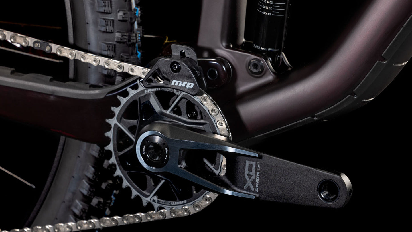 Nahaufnahme eines Carbon-Mountainbike-Antriebsstrangs mit SRAM X01-Kurbelarm, Kettenblatt, MRP-Kettenführung und Reifen vor schwarzem Hintergrund - ideal für das CUBE Stereo ONE44 C:68X SLX 29 liquidviolet'n'black 2025.
