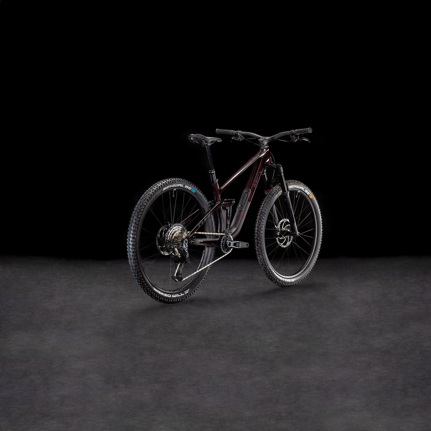 Ein CUBE Stereo ONE44 C:68X SLX 29 liquidviolet'n'black 2026 Mountainbike mit robuster Bereifung ist auf einer dunklen, strukturierten Oberfläche vor schwarzem Hintergrund abgebildet, schräg gestellt, um sein hinteres und seitliches Profil hervorzuheben.