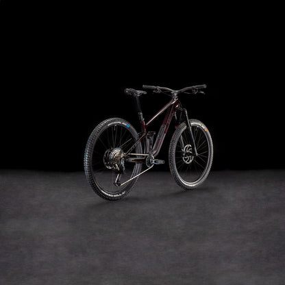 Ein CUBE Stereo ONE44 C:68X SLX 29 liquidviolet'n'black 2026 Mountainbike mit robuster Bereifung ist auf einer dunklen, strukturierten Oberfläche vor schwarzem Hintergrund abgebildet, schräg gestellt, um sein hinteres und seitliches Profil hervorzuheben.