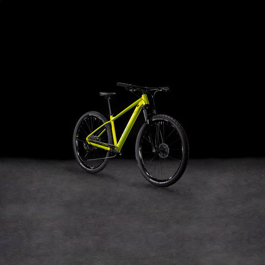 Ein Cube Aim SLX Flashlime´n´Juniper 2025 Mountainbike von CUBE, mit 11-fach Cues Schaltung, schwarzem Lenker, Rädern und Sattel, wird auf einer dunklen strukturierten Oberfläche mit schwarzem Hintergrund präsentiert.