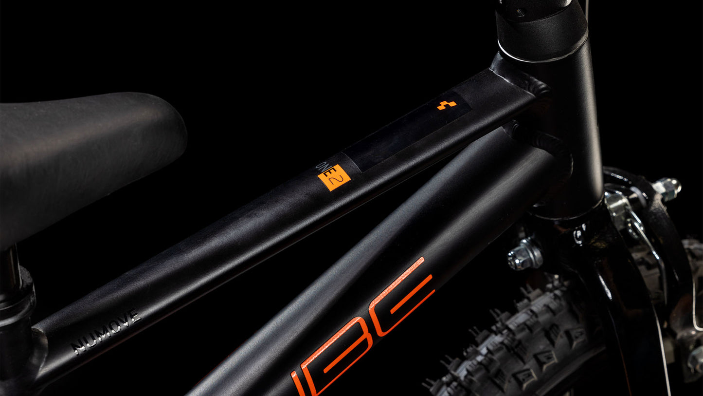 Nahaufnahme eines CUBE Numove 120 RT black'n'orange 2025 Rahmens mit orangem Schriftzug, der den Sitz, das Oberrohr und einen Teil des Hinterrads vor einem schwarzen Hintergrund zeigt.