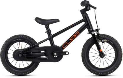 Das Cube Numove 120 RT black'n'orange 2025 ist ein kleines schwarzes Kinderfahrrad von CUBE mit dicken Reifen, gepolstertem Sitz, Felgenbremse, Pedalen mit Kettenschutz und "CUBE" in orange auf dem Rahmen, abgebildet auf weißem Hintergrund.