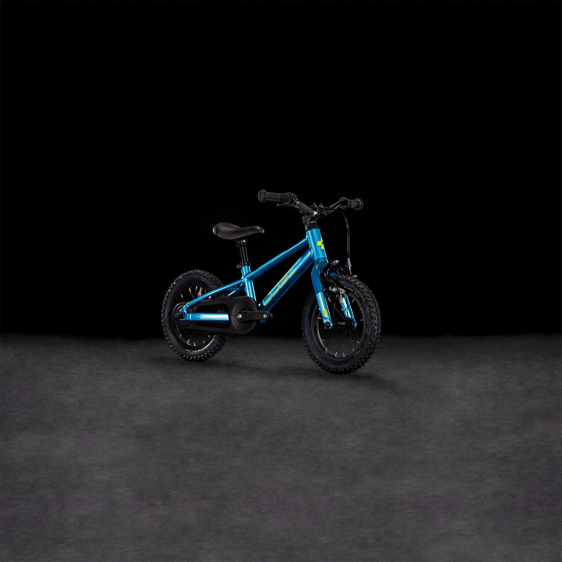 Das Kinderfahrrad CUBE Numove 120 RT blue'n'lime 2025 ist mit Stützrädern, einem schwarzen Sitz, einer Felgenbremse und einem schwarzen Lenker ausgestattet und wird auf einer dunkel strukturierten Oberfläche vor einem schwarzen Hintergrund gezeigt.