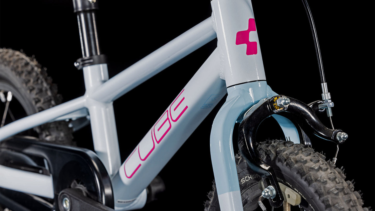 Nahaufnahme eines CUBE Numove 120 RT flashwhite'n'pink 2025, die den Aluminiumrahmen, die Federgabel, die Vorderbremse, das Reifenprofil und einen Teil des Lenkers vor einem schwarzen Hintergrund zeigt.