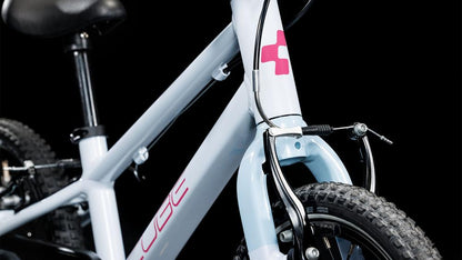 Nahaufnahme des CUBE Numove 140 flashwhite'n'pink 2025 Kinderfahrrads von CUBE, die den Vorderreifen, die Gabel, die V-Brakes und den Rahmen mit pinkem Logo und partiellem "CUBE"-Branding vor schwarzem Hintergrund zeigt.