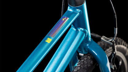 Nahaufnahme des Cube Numove 160 blue'n'lime 2025 von CUBE. Hervorzuheben sind der metallisch blaue Rahmen, der Hinterreifen, die V-Brakes und ein bunter Aufkleber auf dem Oberrohr vor einem schwarzen Hintergrund.