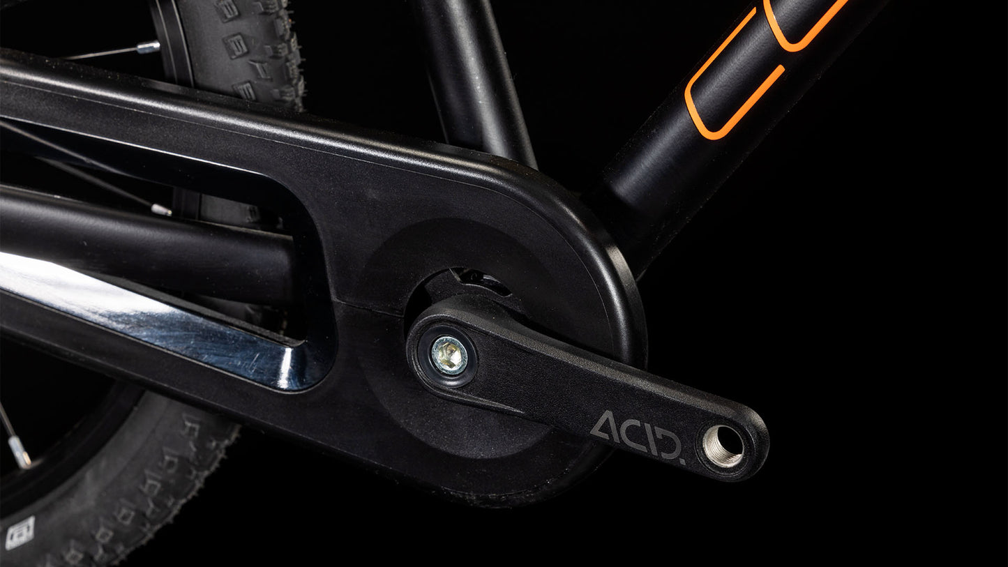 Nahaufnahme eines schwarzen ACID-Kurbelarms, eines Kettenblatts und eines Schwalbe-Reifens am Hinterrad vor einem schwarzen Hintergrund. Der Rahmen des CUBE Numove 180 black'n'orange 2025 All-Terrain-Bikes sticht mit seinen kräftigen orangen Akzenten hervor.