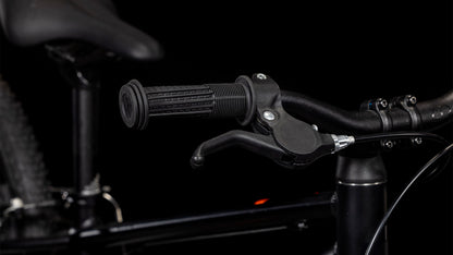 Nahaufnahme des Cube Numove 180 black'n'orange 2025 von CUBE - mit schwarzem Lenker mit strukturiertem Gummigriff, Bremshebel und einem Teil des 6061er-Aluminiumrahmens und -sitzes, perfekt für jeden All-Terrain-Bike-Enthusiasten.