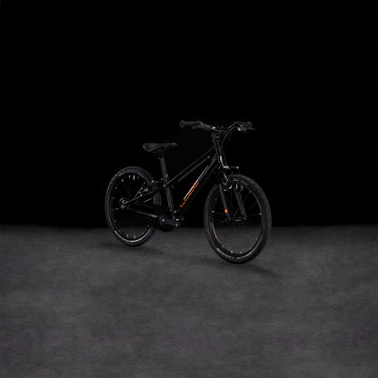 Das CUBE Numove 180 black'n'orange 2025, ein Kinder-Geländefahrrad aus robustem 6061er-Aluminium, zeigt sich im Seitenprofil vor einem dunklen Hintergrund. Der schwarze Rahmen ist mit auffälligen orangefarbenen Akzenten versehen.