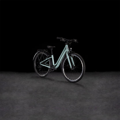 Das CUBE Ella 240 aloegreen'n'white 2025, ein Tiefeinsteigerrahmenrad von CUBE mit schwarzer Bereifung, Shimano 3x8-Schaltung und einem Gepäckträger wird auf einer grauen Fläche vor schwarzem Hintergrund gezeigt.