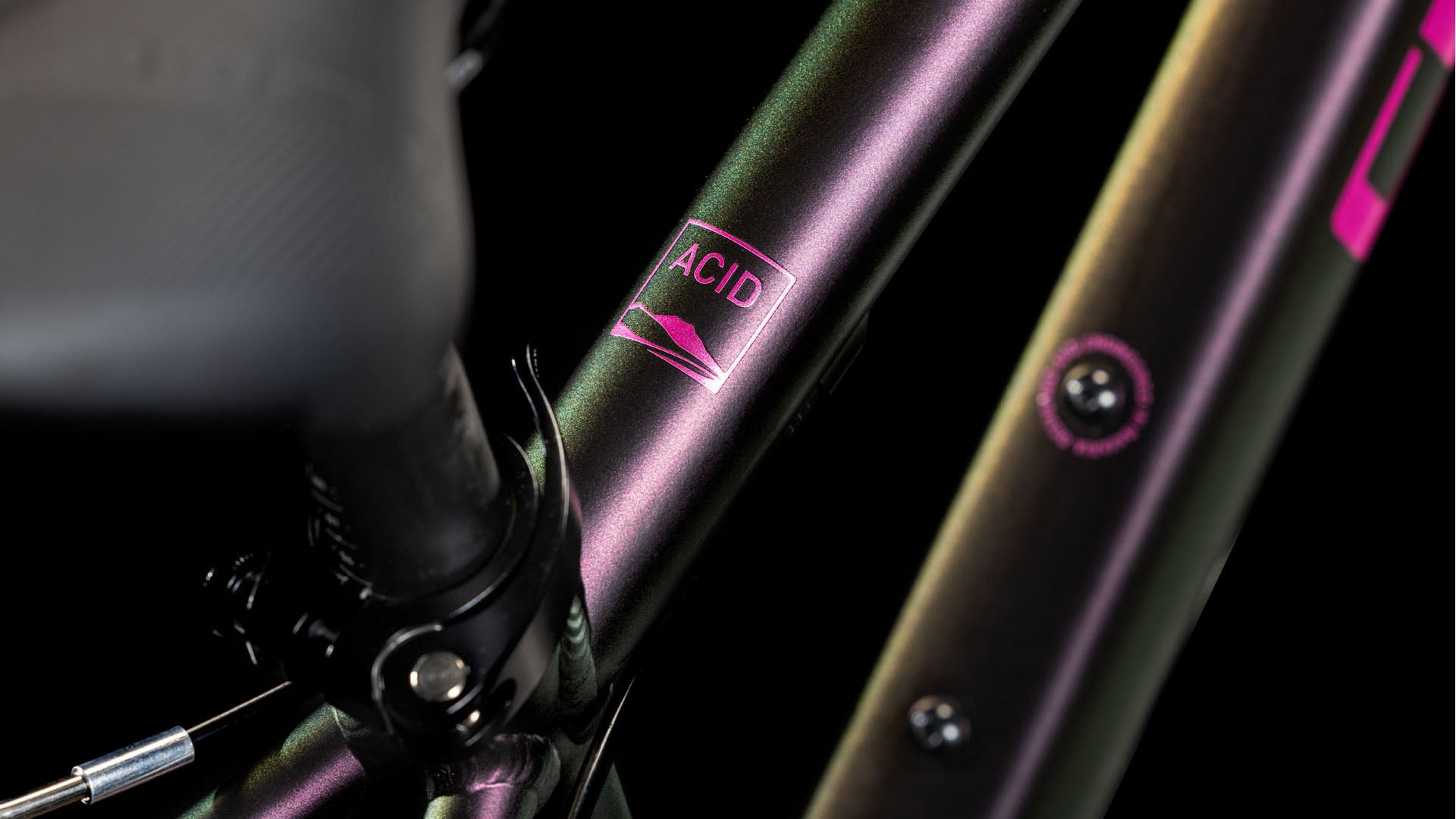 Nahaufnahme des CUBE Acid 200 molotov'n'pink 2025 Rahmens mit irisierender Lackierung und einem 6061 Aluminiumrahmen, der das ACID Label neben einer stilisierten Berggrafik zeigt. Die Details dieses CUBE-Bikes sind scharf umrissen.