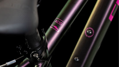 Nahaufnahme des CUBE Acid 200 molotov'n'pink 2025 Rahmens mit irisierender Lackierung und einem 6061 Aluminiumrahmen, der das ACID Label neben einer stilisierten Berggrafik zeigt. Die Details dieses CUBE-Bikes sind scharf umrissen.