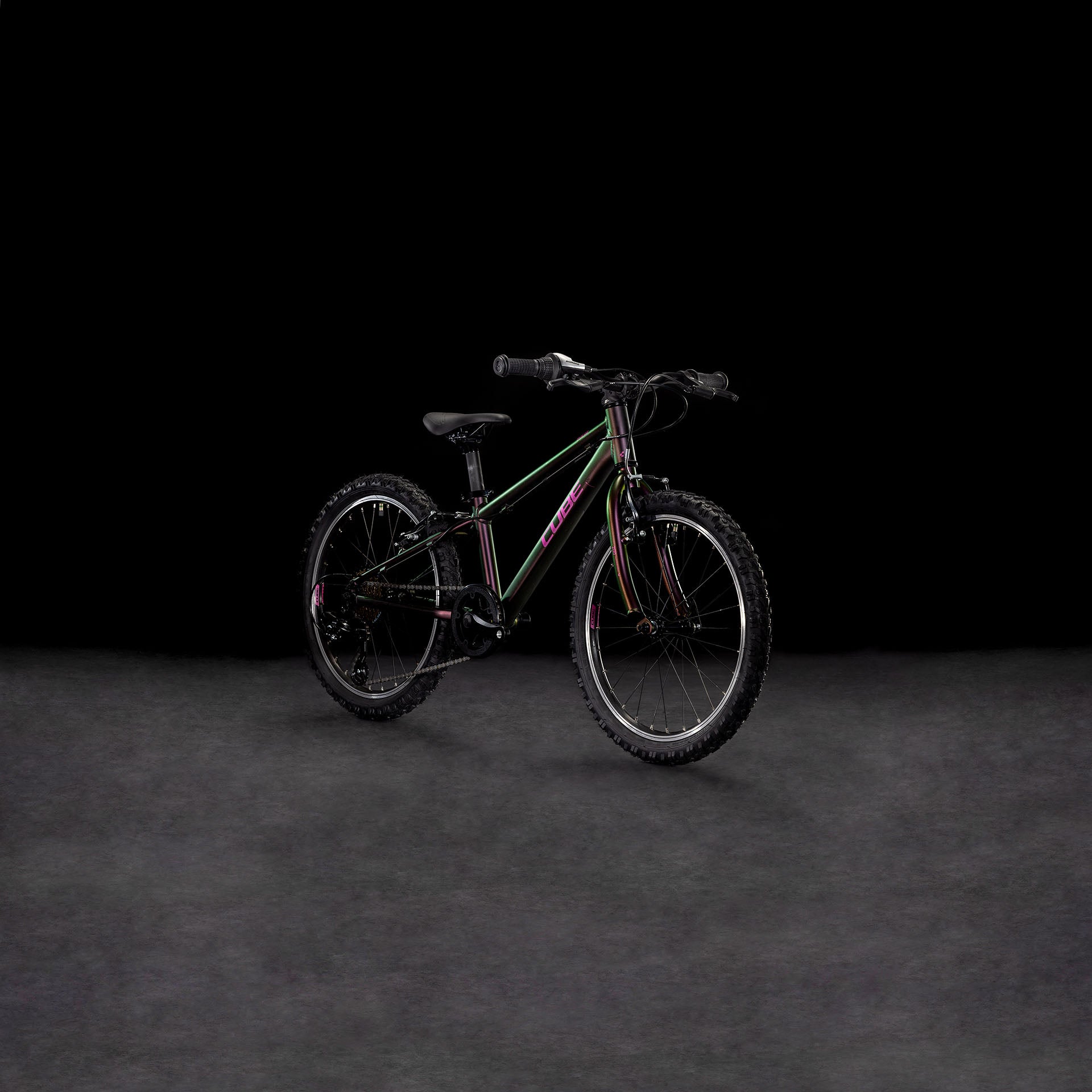 Das CUBE Acid 200 molotov'n'pink 2025 Kinder-Mountainbike mit dicken Reifen und einem stabilen 6061er-Aluminiumrahmen steht auf einer dunklen, strukturierten Oberfläche vor einem schwarzen Hintergrund.
