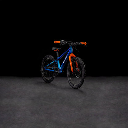 Auf einer dunklen, glatten Fläche vor schwarzem Hintergrund ist das CUBE Acid 200 Disc actionteam 2025 Kinder-Mountainbike in Blau und Orange mit hydraulischen Scheibenbremsen abgebildet.