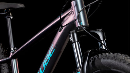 Nahaufnahme des CUBE Acid 260 Disc galactic'n'cyan 2025 Mountainbike-Rahmens mit Aluminiumrohren mit Metallic-Farbverlauf, sichtbarem Lenker, Federgabel, dicken Reifen und partiellem Sitz vor schwarzem Hintergrund. Der Schriftzug "CUBE" in blauen Buchstaben sticht hervor - perfekt für jeden Fahrer.