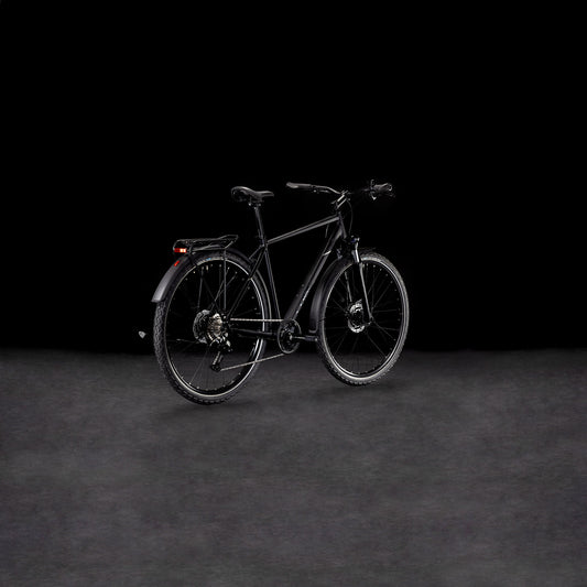 Ein schnittiges CUBE Nature ONE Allroad black'n'black Fahrrad mit Gepäckträger und Schutzblechen steht auf einer nebligen, dunklen Fläche vor einem schwarzen Hintergrund. Sein modernes Design wird schräg hervorgehoben und die hydraulischen Scheibenbremsen sorgen für zuverlässige Bremskraft.