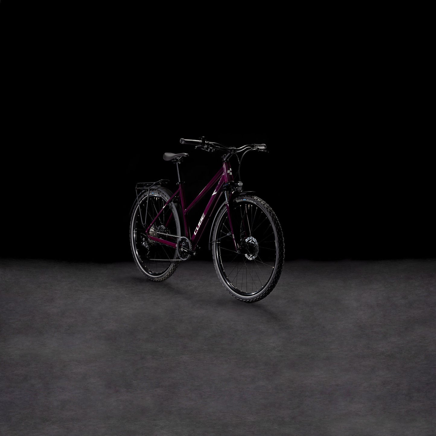 Ein Cube Nature ONE Allroad amarone'n'lunar Trapeze von CUBE, mit schwarzen Reifen und Lenker und einer Shimano 8-Gang Schaltung, steht auf einer dunklen Fläche vor einem schwarzen Hintergrund.