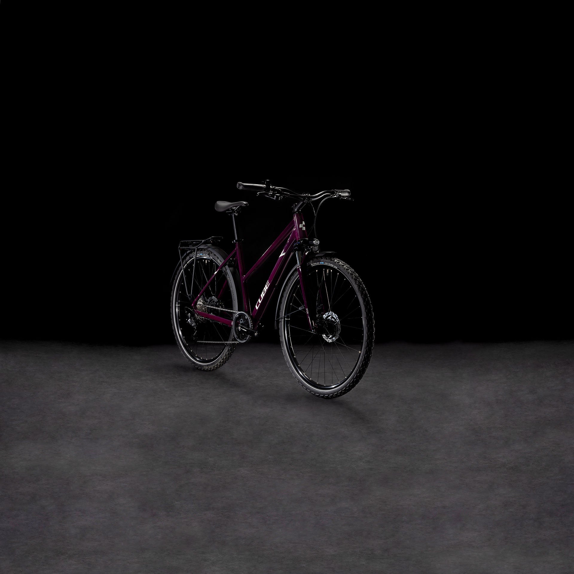 Ein Cube Nature ONE Allroad amarone'n'lunar Trapeze von CUBE, mit schwarzen Reifen und Lenker und einer Shimano 8-Gang Schaltung, steht auf einer dunklen Fläche vor einem schwarzen Hintergrund.