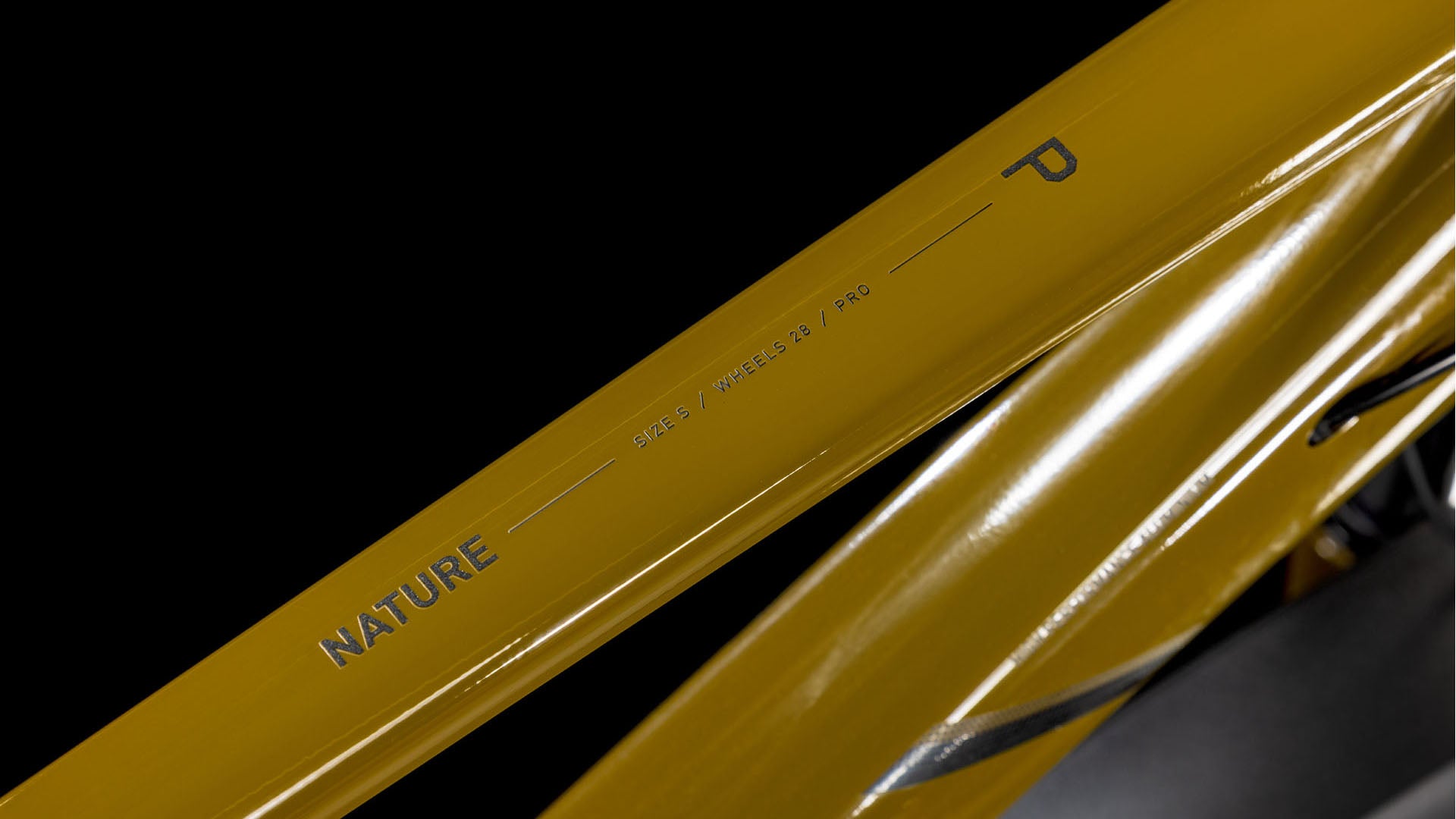 Eine Nahaufnahme des Cube Nature Pro Allroad willowgreen'n'black Trapeze 2025 von CUBE zeigt den leichten Aluminiumrahmen mit den Schriftzügen "NATURE", "SHAPE 1", "WHEELS 29", "PRO" und einem markanten "P" in schwarzer Schrift vor einem schlichten schwarzen Hintergrund.