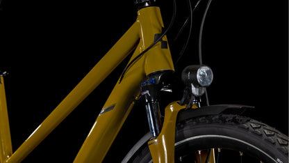 Nahaufnahme der Frontpartie des CUBE Nature Pro Allroad willowgreen'n'black Trapeze 2025 mit Shimano Cues Schaltung, leichtem Aluminiumrahmen, Federgabel, Reifen, Scheinwerfer und Bremszügen vor einem schwarzen Hintergrund.