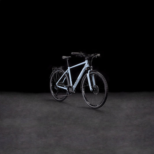 Das CUBE Nature EXC Allroad pigeonblue'n'black Elektrofahrrad mit schwarzen Reifen, Lenker und hydraulischen Scheibenbremsen ist in einem leichten Seitenwinkel auf einem dunklen, neutralen Hintergrund abgebildet.