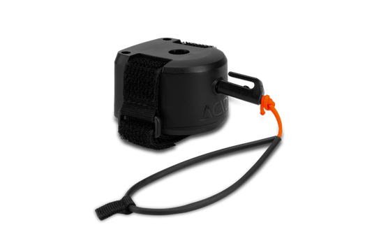 Das Cube ACID Zugsystem MOUNTAIN EXPLORER ist ein schwarzes Handgelenkband mit Kunststoffgehäuse, Klettverschluss und einer orangefarbenen Zugschnur. Die verstellbare Schlaufe sorgt für einen sicheren Sitz - perfekt für Touren mit Kindern.