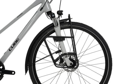Nahaufnahme des Vorderrads eines weißen Fahrrads mit Scheibenbremse und schwarzem ACID Gepäckträger LOWRIDER Suspension MTB Rack. SCHWALBE steht auf dem Reifen und CUBE auf dem Rahmen - ideal für Fahrten rund um Goslar oder zu Ihrem CUBE Store vor Ort.