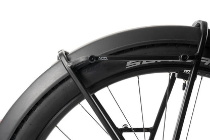 Nahaufnahme eines schwarzen Fahrrad-Hinterrads mit breitem Reifen und einem robusten ACID Gepäckträger SIC 2.0 RAIL von ACID, ideal zur Befestigung von Fahrradtaschen, vor weißem Hintergrund.